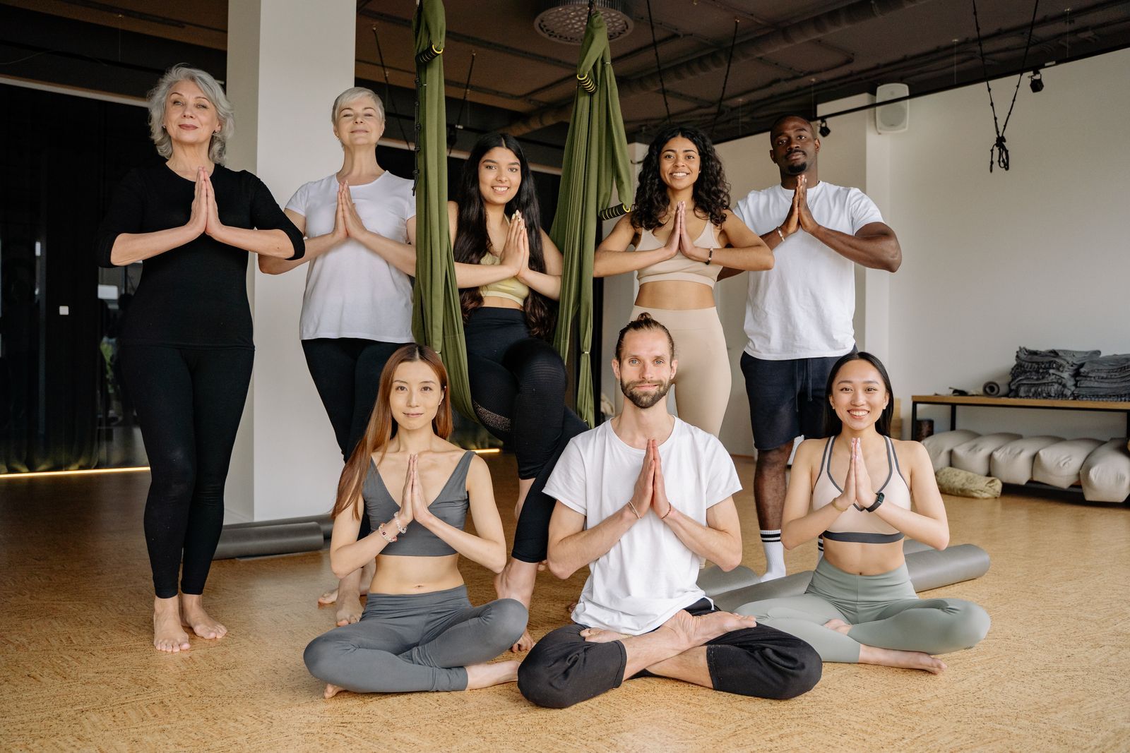 A diverse group of adults practicing yoga together indoors, focusing on mindfulness and flexibility.